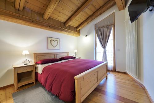 a bedroom with a large bed and a large window at Maso Vaia in Cavalese