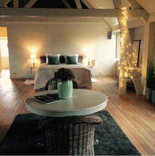 a bedroom with a bed with a table and lights at The Loft in Melsele
