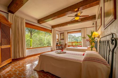 a bedroom with a bed and a large window at Hacienda Uxmal Plantation & Museum in Uxmal