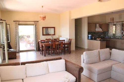 a living room with a couch and a table at Breathtaking seaview villa in a serene scenery in Chavouna