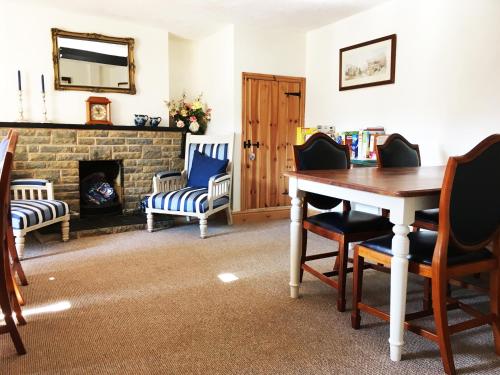 a living room with a table and chairs and a fireplace at Hillside Bed and Breakfast in Crediton
