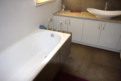 a bathroom with a bath tub and a sink at Dom pod Sosnami in Płaska