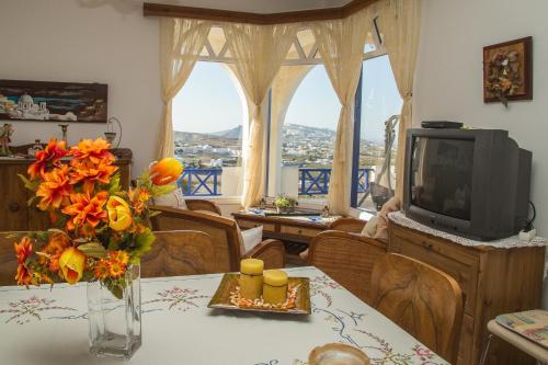 Una sala de estar con una mesa con un jarrón de flores. en Villa Eva with Panoramic view, en Pirgos