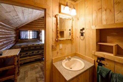 a bathroom with a sink and a bed in a room at Silver Gate Lodging in Cooke City