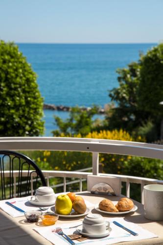 a table with plates of food on a balcony at Hotel Adler in Gabicce Mare