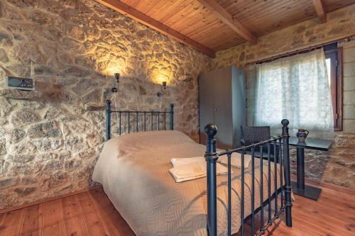 ケラトカンボスにあるKeratokampos Villaの石壁のベッドルーム1室