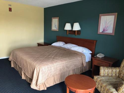 A bed or beds in a room at Americas Best Inn - Savannah I-95