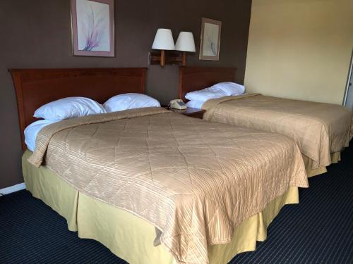 a hotel room with two beds and a room with two at Americas Best Inn - Savannah I-95 in Savannah