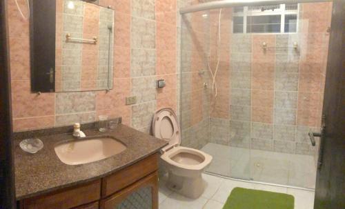 a bathroom with a sink and a toilet and a shower at CASA COM 3 QUARTOS NA PRAIA DE CAIOBA in Matinhos