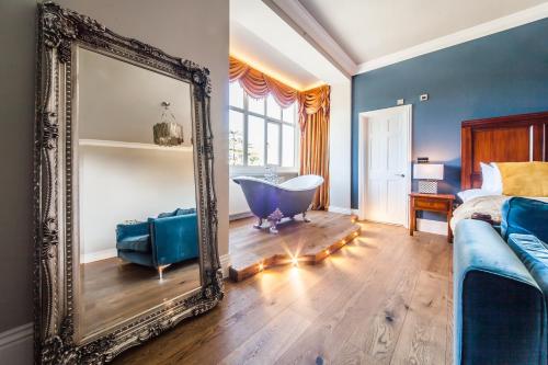 a bedroom with a mirror and a bed and a tub at The Manor at Bickley in Bromley