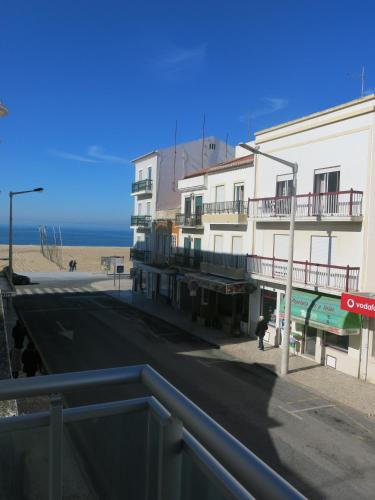 a building on a street next to the beach at OLY BEACH in Nazaré