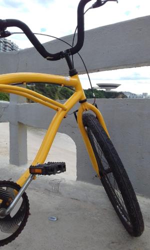 a yellow bike parked next to a fence at Brasileranza Hostel in Niterói