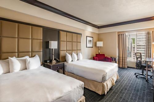 モントリオールにあるホテル ボナベンチャー モントリオールのベッド2台とデスクが備わるホテルルームです。