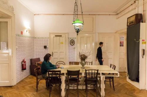 a man and a woman sitting at a table in a room at Baroque Hostel & Coworking in Budapest