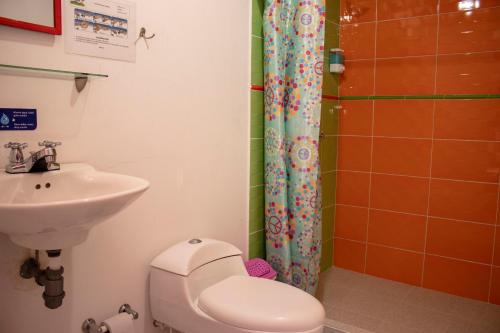 un baño con inodoro y lavabo en Hostal Palmas De Cocora, en Salento