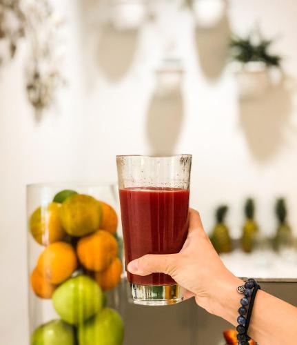 a person holding up a glass of juice at YO1 Longevity & Health Resorts, Catskills in Monticello