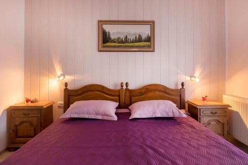 a bedroom with a purple bed with two pillows at Apartment Pula 6 in Veli Vrh