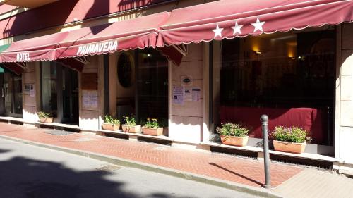 un restaurant avec des plantes en pot à l'avant d'un bâtiment dans l'établissement Primavera, à Levanto