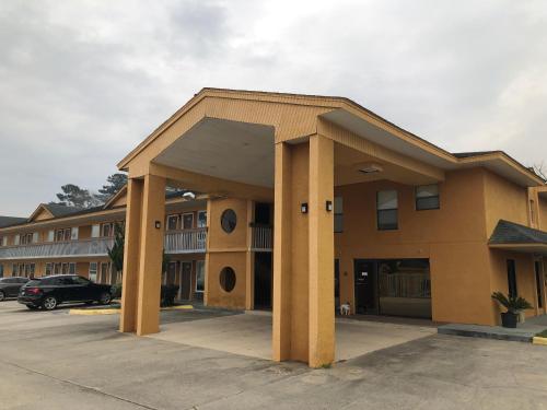 a large building with pillars in a parking lot at Americas Best Inn - Savannah I-95 in Savannah