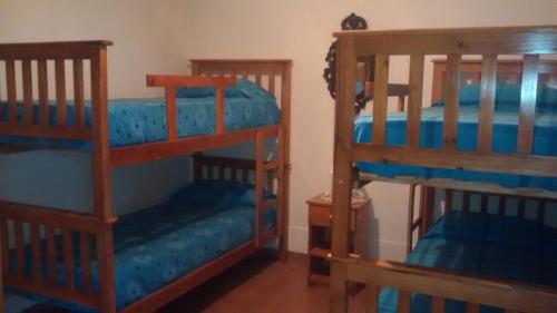 two bunk beds in a room with blue sheets at La Casa de Ana in Bialet Massé