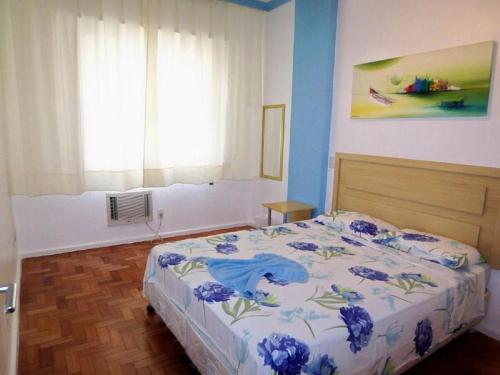 um quarto com uma cama com flores azuis em Aires 92 no Rio de Janeiro