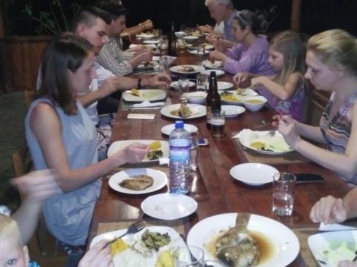 カルピティヤにあるOcean View Beach Resort - Kalpitiyaの食卓に座って食べる人々