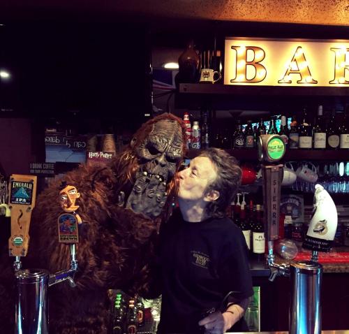 Ein Mann steht hinter einer Bar mit einer Gorillastatue. in der Unterkunft Redwoods River Resort & Campground in Leggett