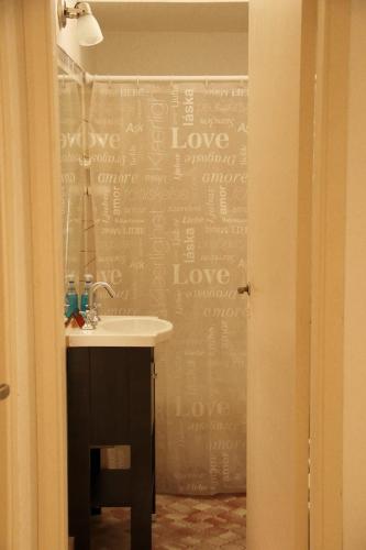 un baño con lavabo y una pared con amor escrito en él en Villarino en Bahía Blanca