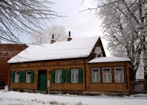 a wooden house with a snow covered roof at Ezera Maja in Liepāja