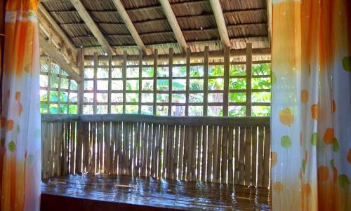 a window in a bamboo building with a curtain at Acuario Beach Inn in San Vicente