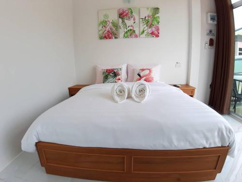 a bedroom with a bed with two shoes on it at บ้านสวนนิสา in Sattahip
