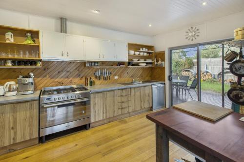 Windsong في باينسفيل: مطبخ كبير مع دواليب خشبية وطاولة