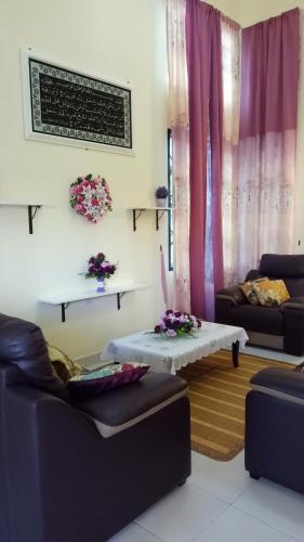 a living room with purple curtains and a table at Gambang Homestay BangloMuslim in Kuantan
