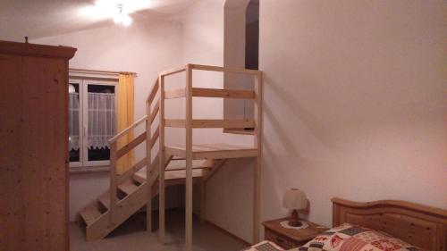 a wooden staircase in a bedroom with a bed at Haus Ruf in Windischgarsten