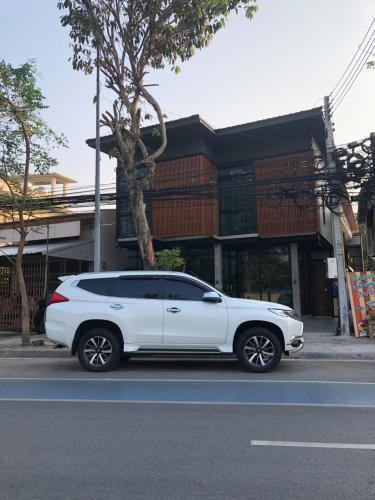 a white car parked on the side of a street at SP Home BangSaen in Bangsaen
