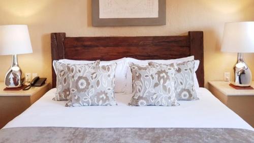 a bedroom with a white bed with pillows and two lamps at Casa Aurea Hotel Boutique in Morelia