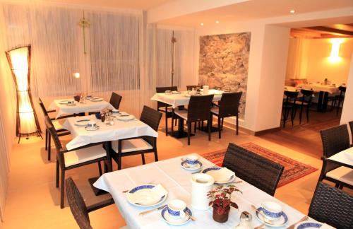 a dining room with tables and chairs with white tables and chairsktop at Villa Egger in Lofer