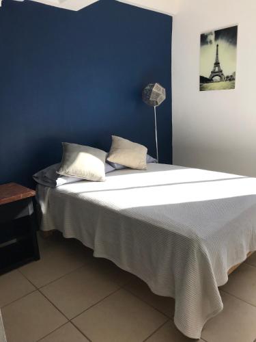 a bedroom with a large bed with a blue wall at Cómodo y lindo depa con Alberca in Puerto Vallarta