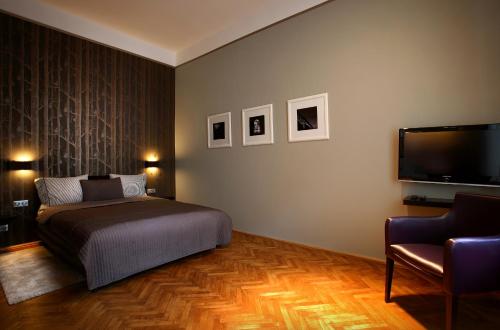 a bedroom with a bed and a flat screen tv at Gateway Budapest City Center in Budapest