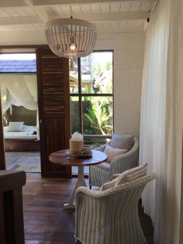 a living room with a table and chairs and a chandelier at Mangga Wangga Living in Uluwatu