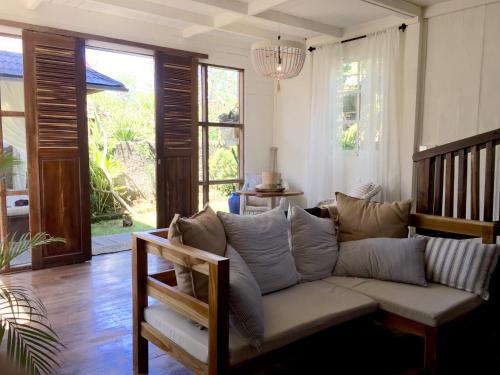a living room with a couch and some windows at Mangga Wangga Living in Uluwatu