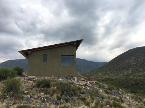 a house on a hill with mountains in the background at La casa de la paz in Potrerillos
