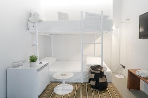 a white room with a bed and a desk at Chocolate box mint - SHA Plus in Bangkok