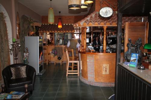 a bar in a restaurant with a clock on the wall at Hotel Copacabana Tarifa Beach in Tarifa
