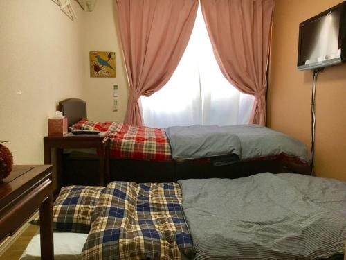 Duas camas num quarto com uma janela em Ys Bed & Kitchen Tokyo #HY1 em Tóquio