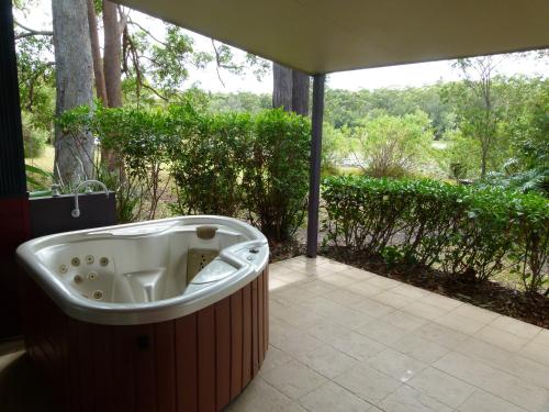 a jacuzzi tub sitting on a patio at Lake Russell Lakeside Retreat in Emerald Beach