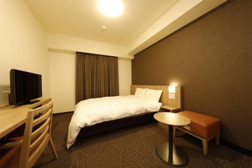 מיטה או מיטות בחדר ב-Dormy Inn Maebashi