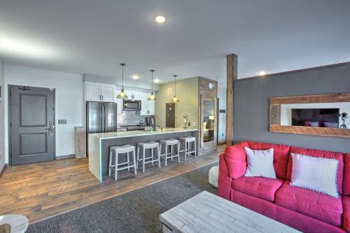 a living room with a red couch and a kitchen at Hotel Crosby in Stillwater