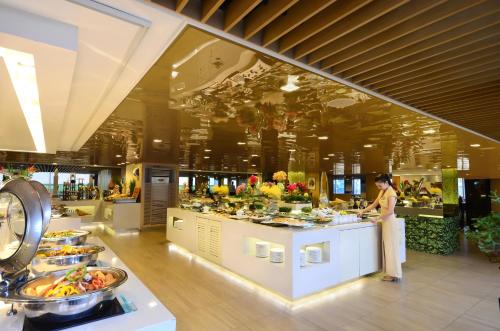 a woman standing in front of a buffet in a restaurant at Midas Hotel and Casino in Manila