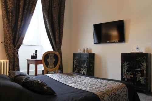 a bedroom with a bed and a flat screen tv at Résidence et Chambres d'Hôtes de La Porte d'Arras in Douai